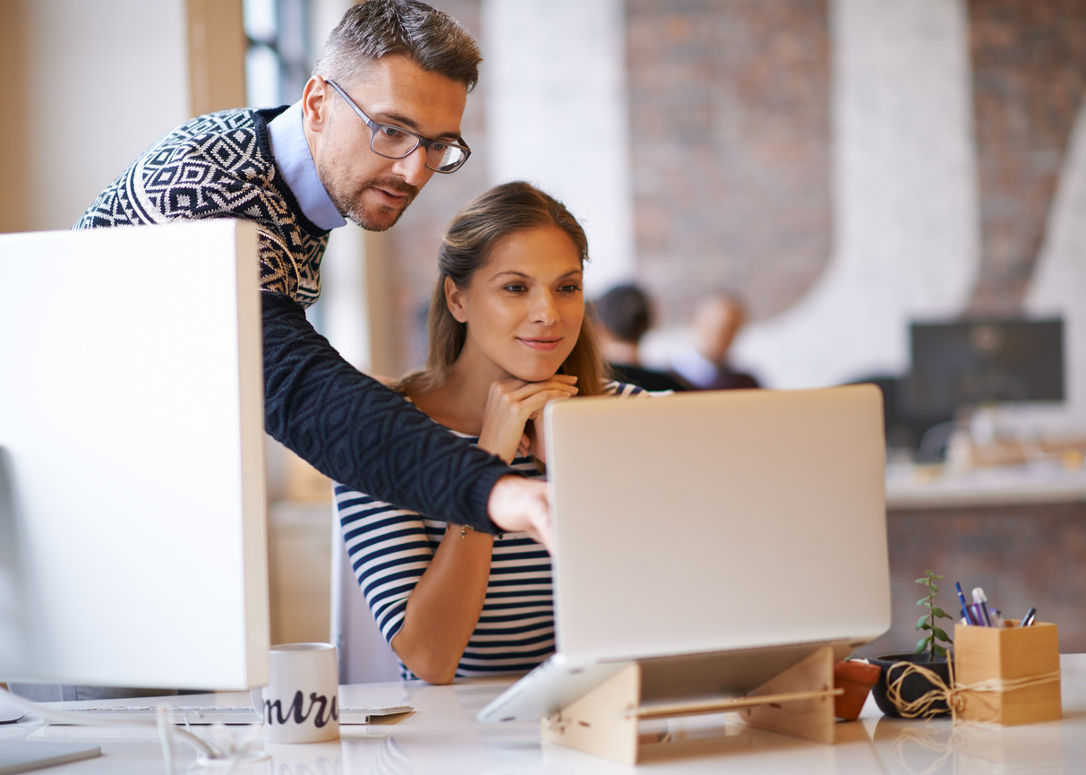 Shot of two designers working together at a computer to design a new website