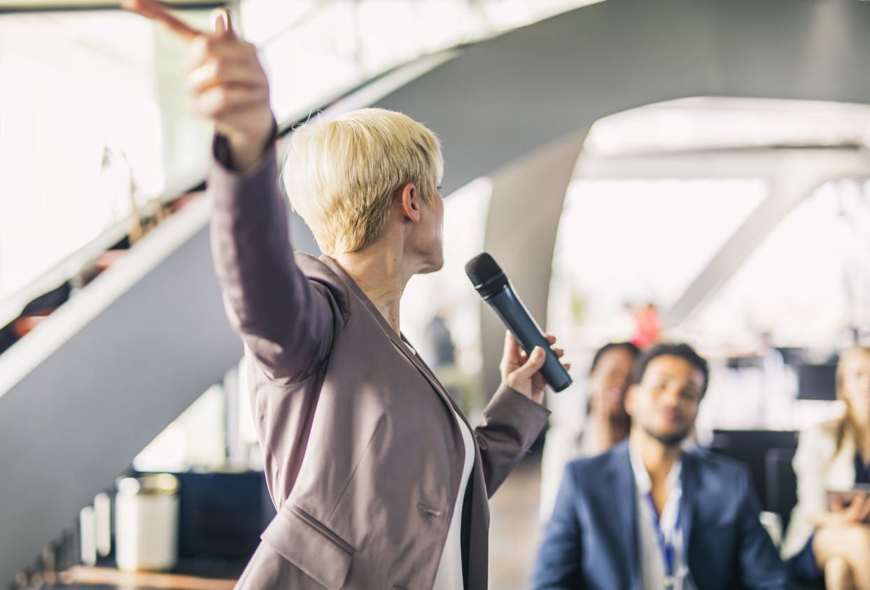 A Mature Presenter Interacting With The Audience At A Business Presentation In The Board Room